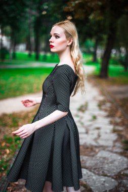 Kırmızı ruj büyük parlak gözleri olan, genç güzel sarışın kız ve sokaklarda ayar güneş trendy kıyafetler poz elbise yapmak