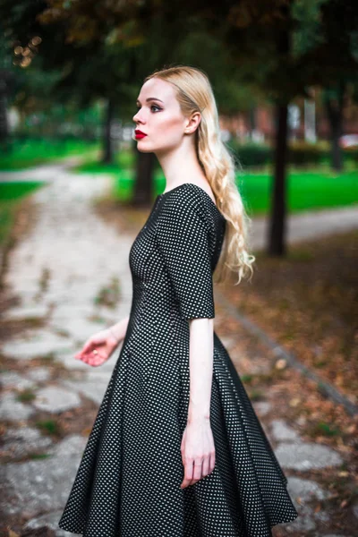 Jovem linda menina loira com batom vermelho em seus grandes olhos brilhantes e torná-lo em vestido posando nas ruas, o pôr do sol roupas da moda — Fotografia de Stock