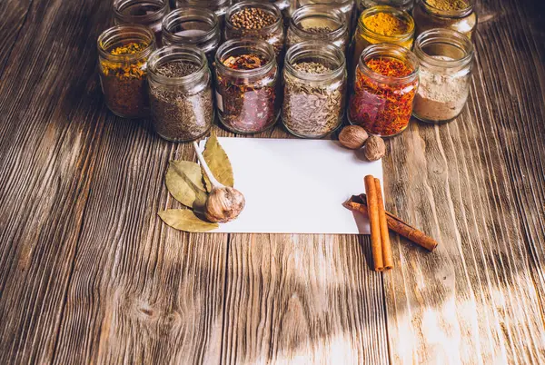 Différents types colorés d'épices sur table en bois rustique, vue de dessus avec espace de copie — Photo