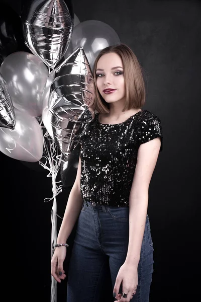 Close up fashion portrait of a young beautiful elegant girl with bright party make up in evening black sequin top. She is keeping silver stars balloons in her hand. Girl at the party. Retouched shot — Stock Photo, Image