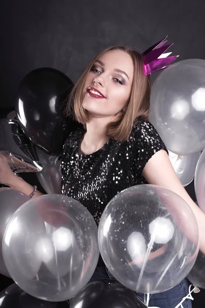 Close up fashion portrait of a young beautiful elegant girl with bright party make up in evening black sequin top. She is keeping silver stars balloons in her hand. Girl at the party. Retouched shot — Stock Photo, Image