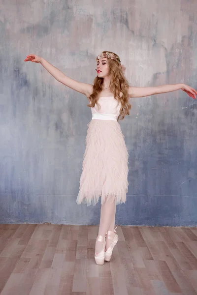 美腿的年轻芭蕾舞演员，舞蹈在白色的木地板背景与复制空间。芭蕾舞练习。漂亮苗条优美芭蕾舞演员。春天和浪漫的气氛 — 图库照片