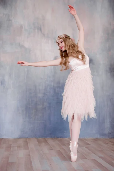 Pernas bonitas de bailarina jovem dançando no fundo do chão de madeira branco, com espaço de cópia. Treino de ballet. Bela dançarina de balé graciosa e fina. Primavera e atmosfera romântica — Fotografia de Stock