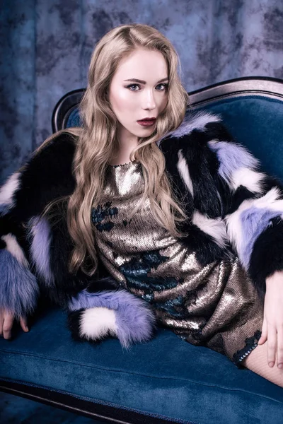 Pullu elbise ve Mavi kürk manto içinde poz çekici genç kadın. Stüdyo imge