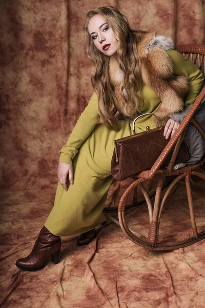 Glamoroso retrato de una hermosa joven en un chaleco de piel sosteniendo una bolsa — Foto de Stock