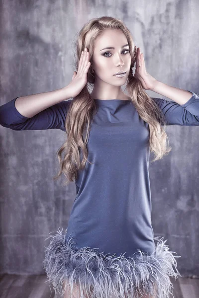 Young and emotional woman in fashion dress over glamour background