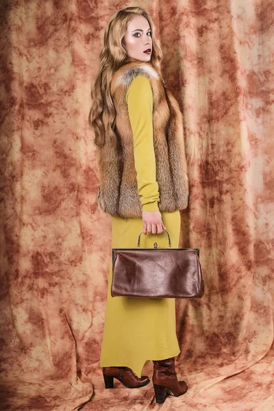 袋を保持している毛皮のベストの美しい若い女性のグラマラスな肖像画 — ストック写真