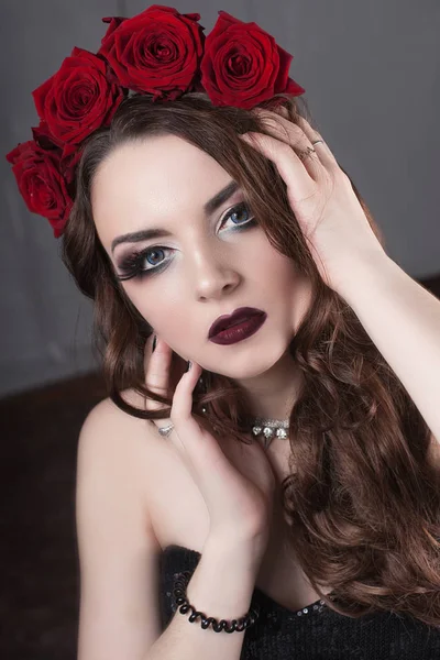 Krásná mladá žena s růží květinou ve vlasech. krásy dívka s make-up tmavém pozadí. tmavě červené lips.close-up módní retušované portrét — Stock fotografie