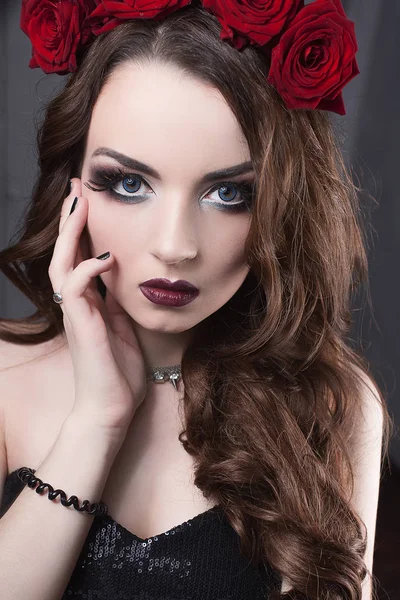 Bela jovem com flores de rosas no cabelo. menina de beleza com maquiagem sobre fundo escuro. lips.close-up vermelho escuro moda retocada retrato — Fotografia de Stock
