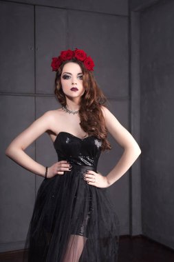 Gül çiçek saç, güzel genç kadın koyu arka plan üzerinde Gotik bir atmosfer makyaj ile siyah elbise giymiş. koyu kırmızı lips.close-up moda düzeltisiz portre