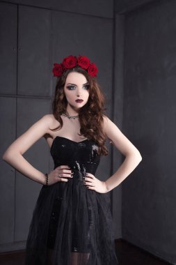Gül çiçek saç, güzel genç kadın koyu arka plan üzerinde Gotik bir atmosfer makyaj ile siyah elbise giymiş. koyu kırmızı lips.close-up moda düzeltisiz portre