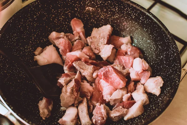 Food ingridients: meat, onion, ginger for recipe stewed beans with meat frying in a pen on a stove. Steps in cooking, process of preparing food. Concept of homemade healthy food.