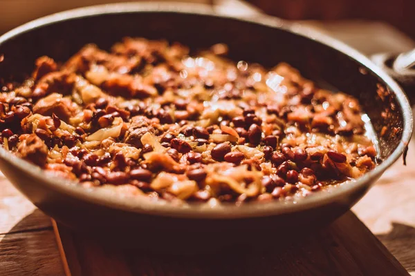 Food ingridients: meat, onion, ginger for recipe stewed beans with meat frying in a pen on a stove. Steps in cooking, process of preparing food. Concept of homemade healthy food.