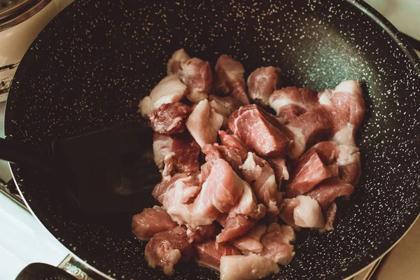 Food ingridients: meat, onion, ginger for recipe stewed beans with meat frying in a pen on a stove. Steps in cooking, process of preparing food. Concept of homemade healthy food.