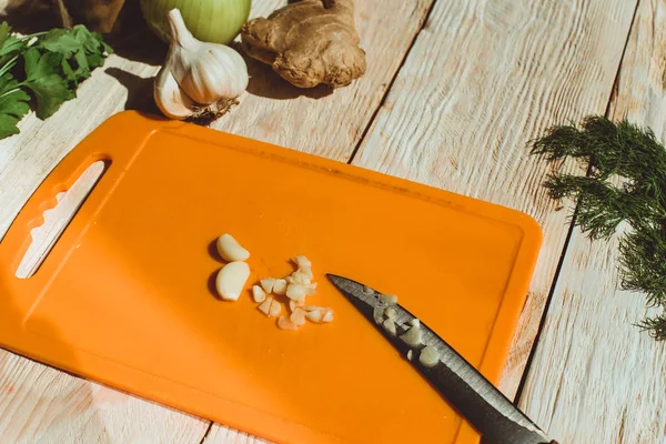 Food ingridients: garlic, onion, ginger for recipe stewed beans with meat on wooden background. Steps in cooking, process of preparing food. Concept of homemade healthy food.