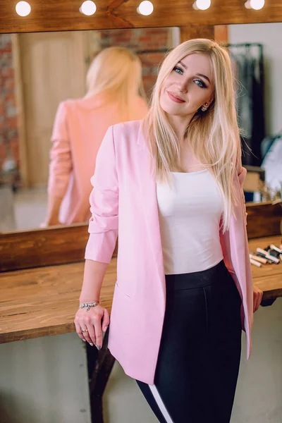 Make-up artist pozitivní krásná blondýnka pózuje u zrcadla v maskérně — Stock fotografie