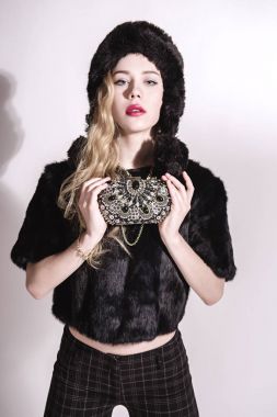 Güzel genç kadın kürk şapka ve siyah ceket küçük ihale. Sarışın kız. Kış moda Beauty.Healthy saç