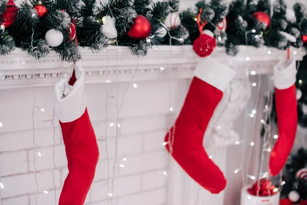 Uma imagem próxima de lindamente decorado meias de Natal vermelho brilhante pendurado em uma lareira à espera de presentes . — Fotografia de Stock