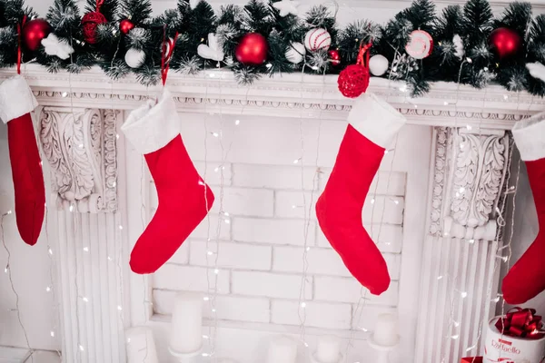 Una imagen cercana de calcetines de Navidad bellamente decorados de color rojo brillante colgando de una chimenea esperando regalos . — Foto de Stock