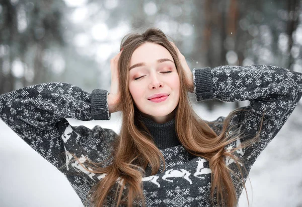 Süveter giyen güzel esmer bir kadının kış portresi. Kar yağan kış güzellik moda konsepti.