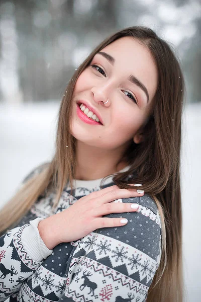 Süveter giyen güzel esmer bir kadının kış portresi. Kar yağan kış güzellik moda konsepti.