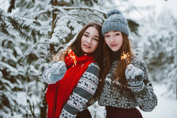 Dwóch przyjaciół dziewczyny młode nastoletnie hipster razem. Moda piękny portret uścisków dwie siostry z bliska i zabawy, trzymając ognie czas Las, noszenie swetry i szaliki, przyjaciele para o — Zdjęcie stockowe