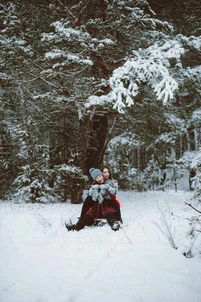 Dos jóvenes amigas adolescentes hipster juntos.Acercamiento retrato de moda de dos hermanas abrazos y divertirse, paseo en trineo en el bosque de invierno, usando suéteres y bufandas, mejores amigos pareja outdoo — Foto de Stock