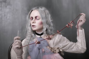 Karanlık halloween bir sandalyede oturuyor ve kalpleri toplayarak korkunç kötü zombi kız portresi. Kavramsal fotoğraf