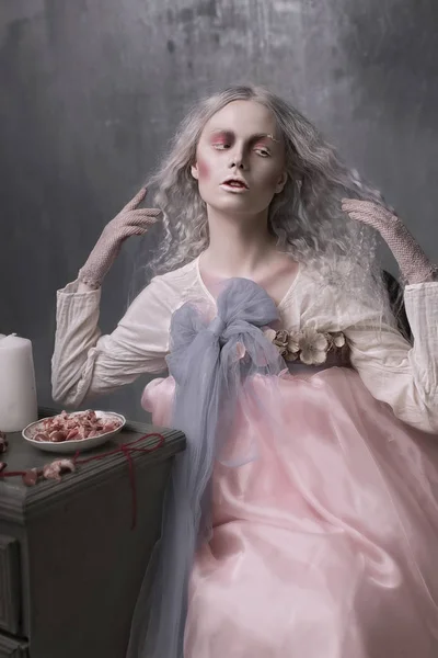 Тёмный Хэллоуин портрет страшной плохой зомби-девушки, сидящей в кресле и собирающей сердца. Концептуальное фото — стоковое фото
