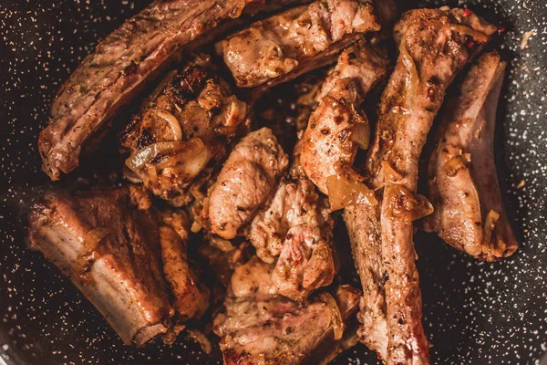 Geroosterde varkensvlees ribben met ui in koekenpan, bovenaanzicht — Stockfoto