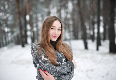 Süveter giyen güzel esmer bir kadının kış portresi. Kar yağan kış güzellik moda konsepti.