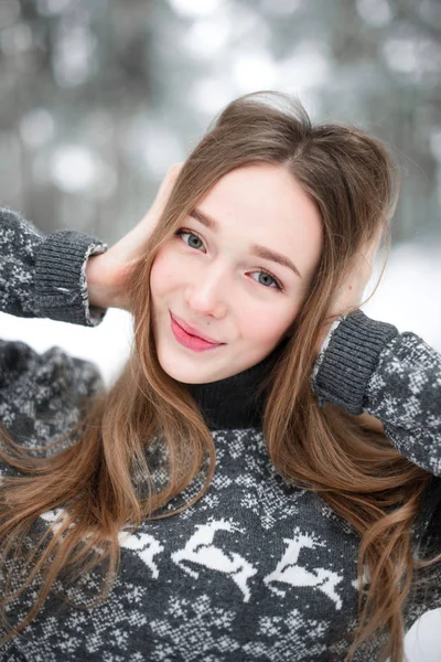 Süveter giyen güzel esmer bir kadının kış portresi. Kar yağan kış güzellik moda konsepti.