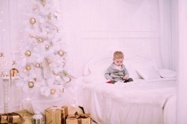 Noel ağacı, altın ve bej pastel c oynayan neşeli küçük oğlu