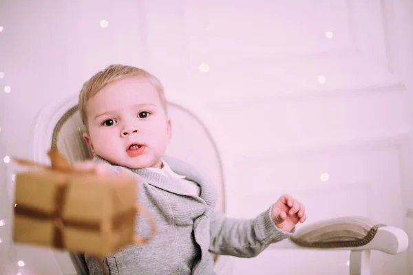 Allegro bambino che gioca con i regali e regali vicino all'albero di Natale, oro e beige pastello c — Foto Stock