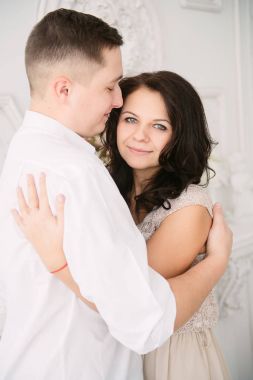 Genç Avrupa çift kucaklayan ve dekore edilmiş studio, öpüşme aşık dating hafif pastel renkler.