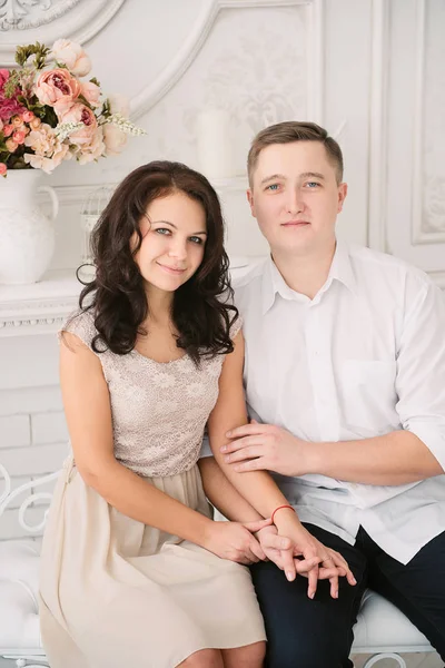 Jovem alegre casal europeu no amor abraçando e beijando em estúdio decorado, cores pastel luz, namoro . — Fotografia de Stock