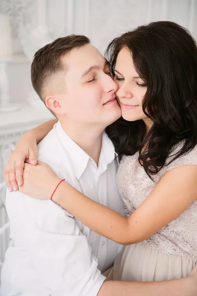 Joven pareja europea alegre en el amor abrazar y besar en estudio decorado, colores pastel claro, citas . — Foto de Stock