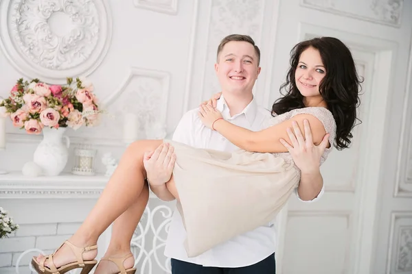 Jeune couple européen joyeux amoureux embrassant et embrassant dans un studio décoré, couleurs pastel clair, datant . — Photo