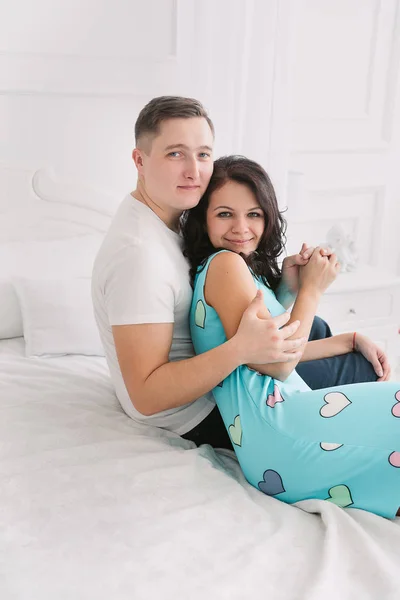 Jeune couple européen joyeux amoureux embrassant et embrassant dans un studio décoré, couleurs pastel clair, datant . — Photo