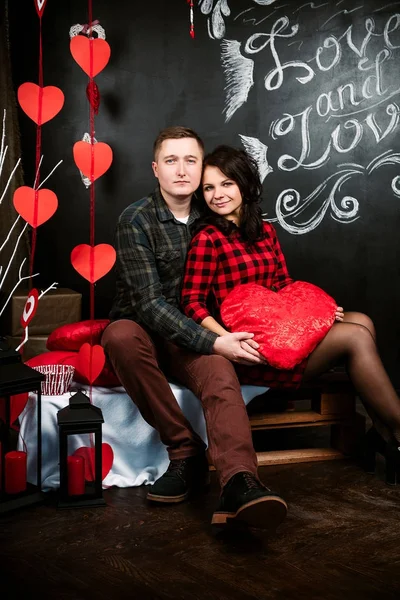 Jeune couple européen joyeux amoureux embrassant et embrassant, décoré avec coeur studio le jour de la Saint-Valentin, datant . — Photo