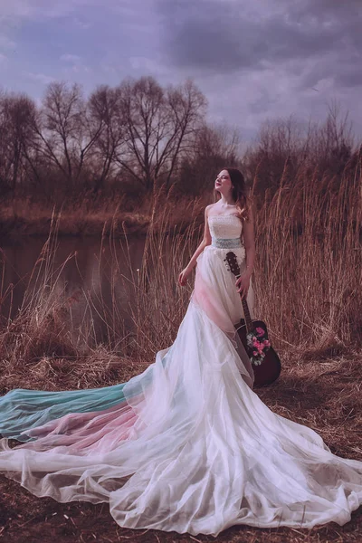 İçinde çiçekler olan güzel, romantik Avrupalı bir kız, dışarıda poz veriyor. Müzik ve doğa kavramı. Bahar geldi..