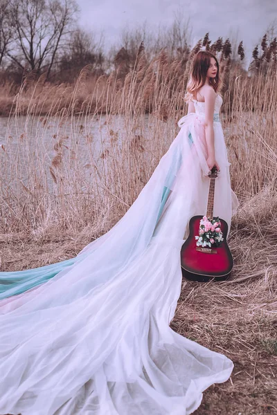 İçinde çiçekler olan güzel, romantik Avrupalı bir kız, dışarıda poz veriyor. Müzik ve doğa kavramı. Bahar geldi..