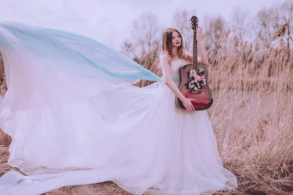 İçinde çiçekler olan güzel, romantik Avrupalı bir kız, dışarıda poz veriyor. Müzik ve doğa kavramı. Bahar geldi..