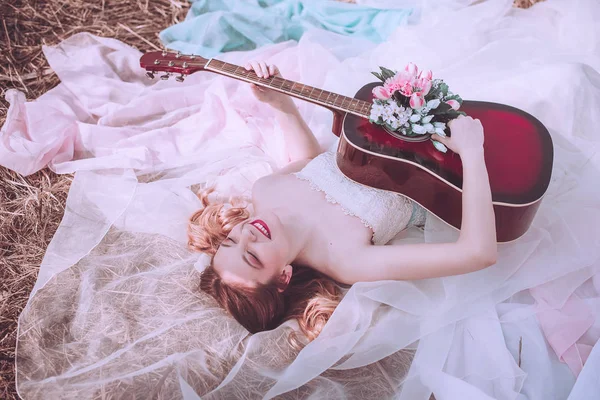 İçinde çiçekler olan güzel, romantik Avrupalı bir kız, dışarıda poz veriyor. Müzik ve doğa kavramı. Bahar geldi..