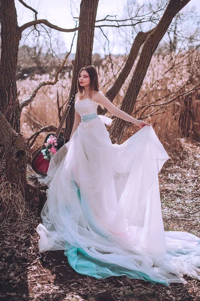 Menina europeia romântica bonita com guitarra com flores dentro, posando ao ar livre. Conceito de música e natureza. Hora da Primavera . — Fotografia de Stock