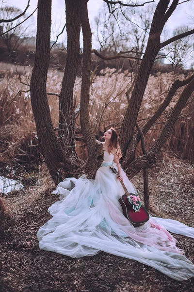 İçinde çiçekler olan güzel, romantik Avrupalı bir kız, dışarıda poz veriyor. Müzik ve doğa kavramı. Bahar geldi..