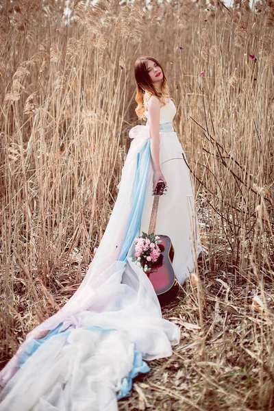 Menina europeia romântica bonita com guitarra com flores dentro, posando ao ar livre. Conceito de música e natureza. Hora da Primavera . — Fotografia de Stock