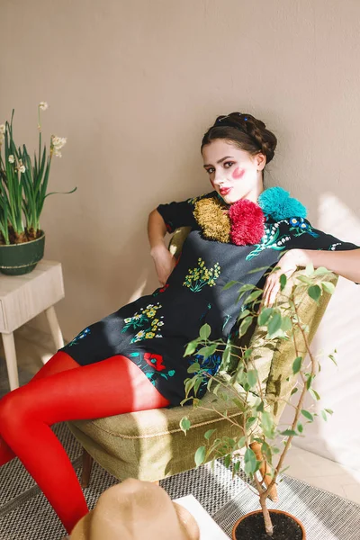Chica morena hermosa de moda en un mono con bordado floral con maquillaje de color: mejillas rojas y labios. Estilo elegante abuela. Retrato retocado — Foto de Stock