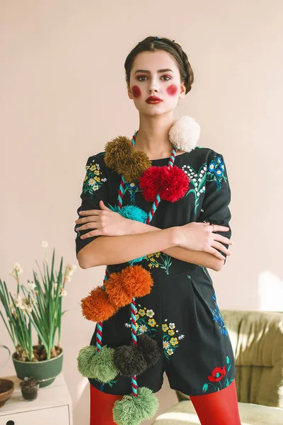 Menina morena bonita na moda em um macacão com bordado floral com maquiagem a cores: bochechas vermelhas e lábios. Avó estilo chique. Retrato retocado — Fotografia de Stock