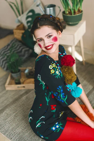 Menina morena bonita na moda em um macacão com bordado floral com maquiagem a cores: bochechas vermelhas e lábios. Avó estilo chique. Retrato retocado — Fotografia de Stock